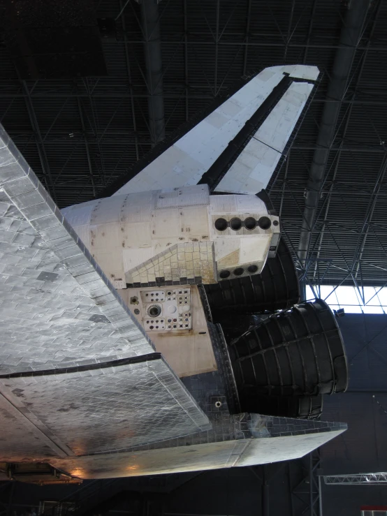 a space shuttle sitting in the hangar for maintenance