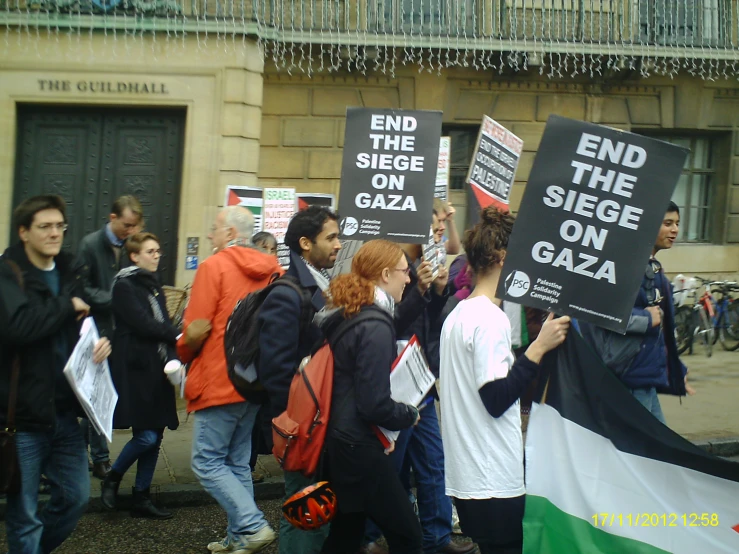 a bunch of people holding signs and wearing banners