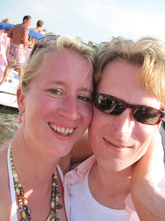 two smiling women posing for the camera while wearing necklaces