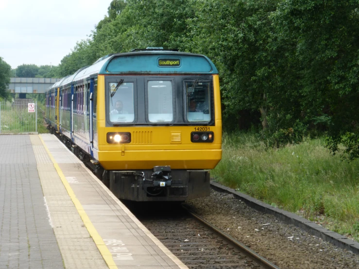 yellow and blue train sitting next to a train platform