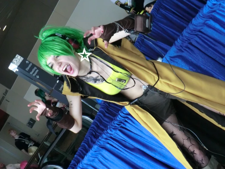 a woman with green hair is posing on a stage