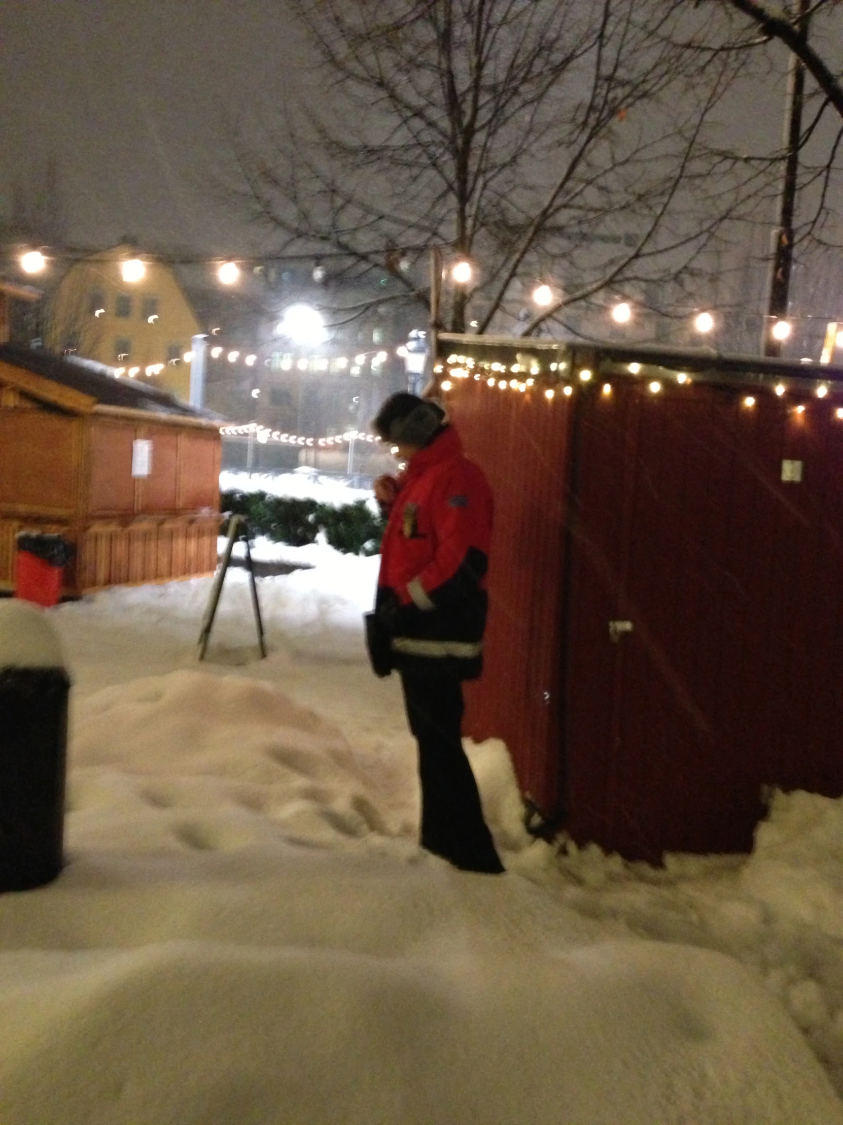 a snowboarder standing in the snow at night