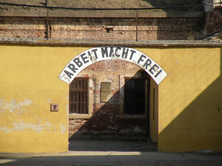 an arched doorway sits in the middle of a yellow building