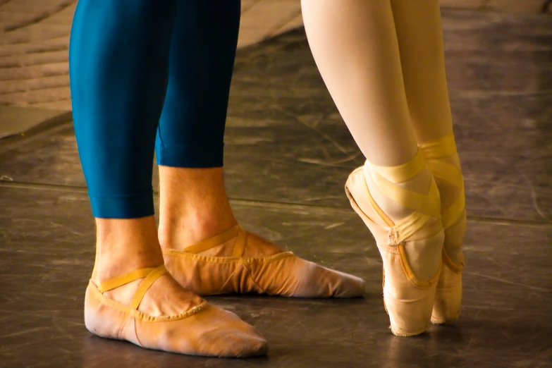 two people wearing ballet shoes standing together