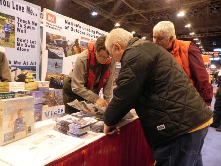 an older man is buying items at an event