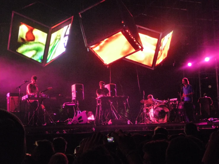 a band plays on stage with brightly colored lights