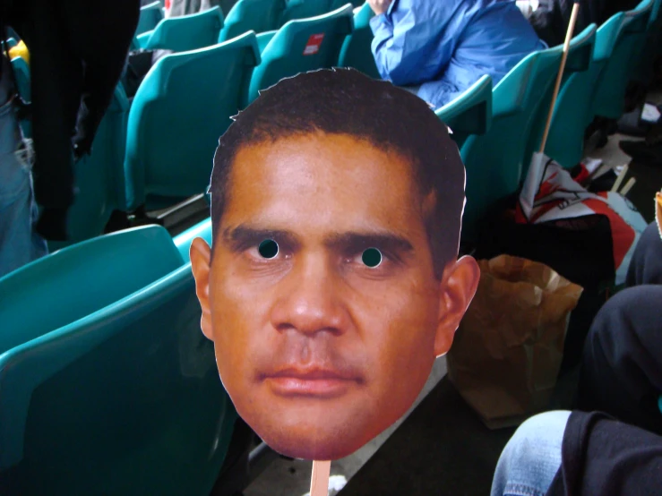 a cardboard cutout of an african man sits in the stands