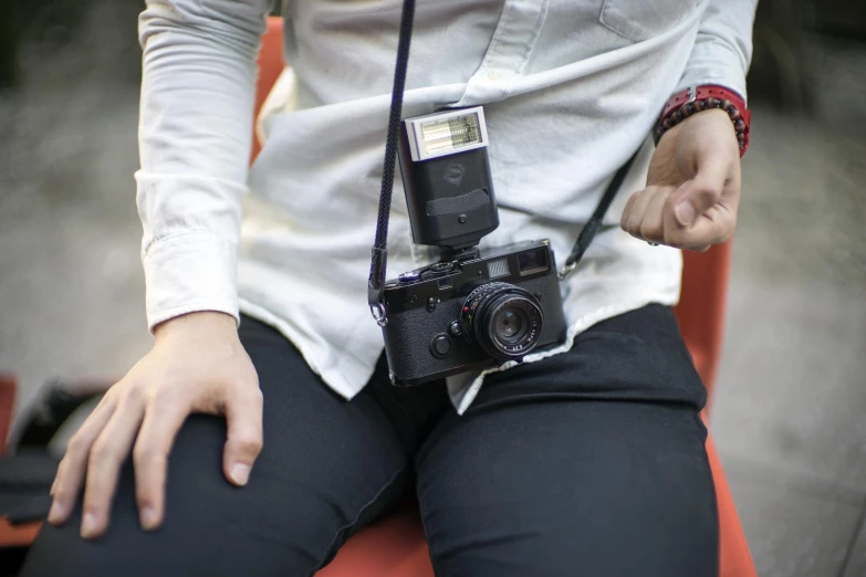 a man sits down holding a camera to his right shoulder