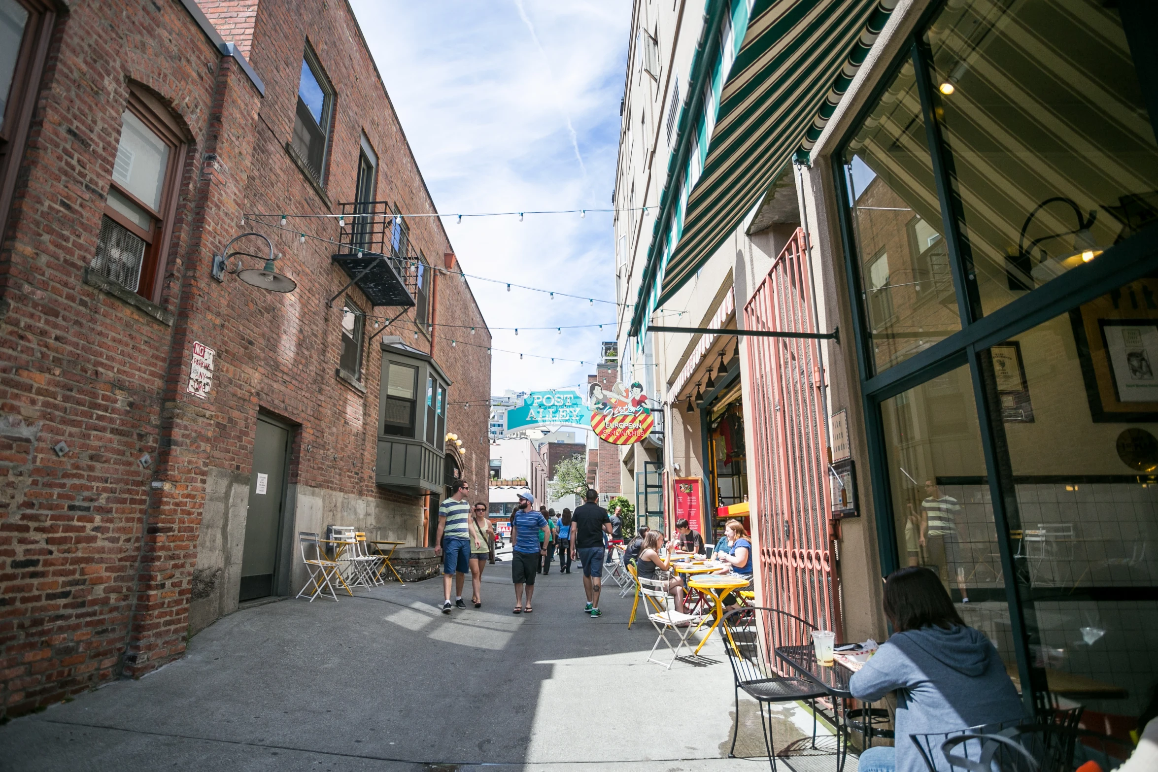 a sidewalk with people walking down it near buildings