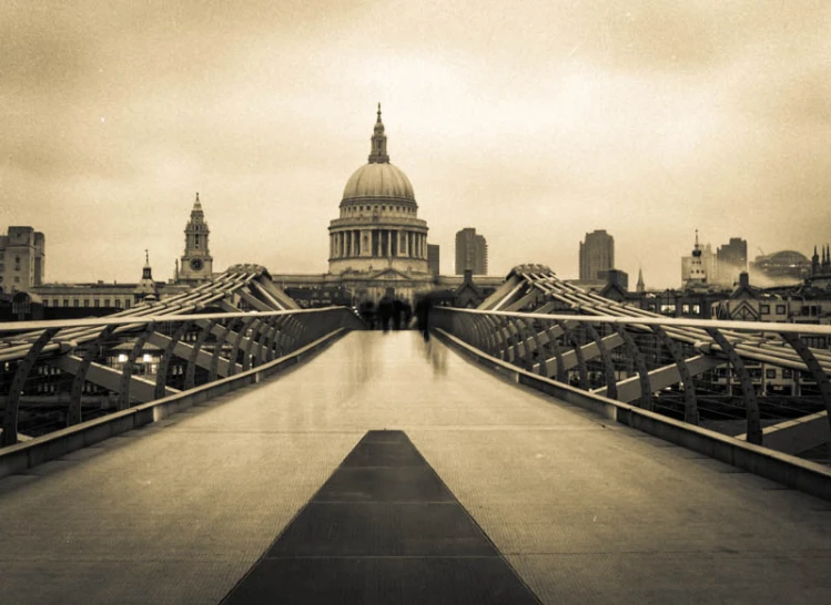 a very wide bridge with some buildings in the background