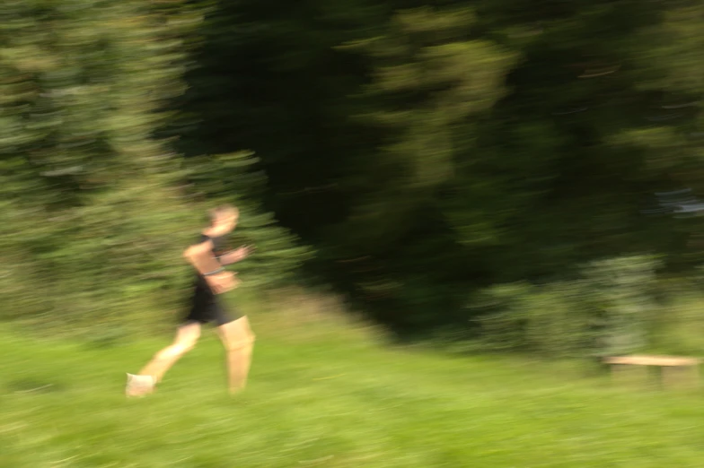 blurry pograph of man jogging in park next to trees