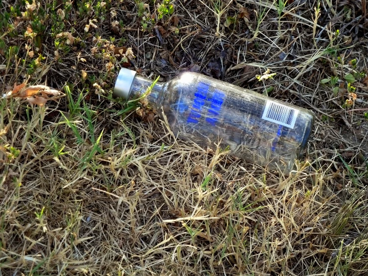 a old bottle of water that is laying on the ground