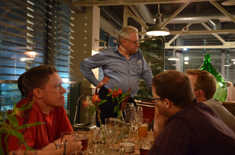 a group of people sitting at tables drinking wine