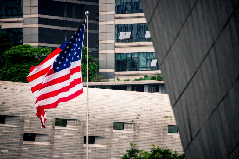 a large american flag next to a building