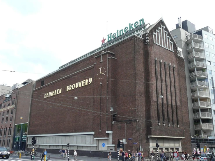 people on bicycles ride past the brick building