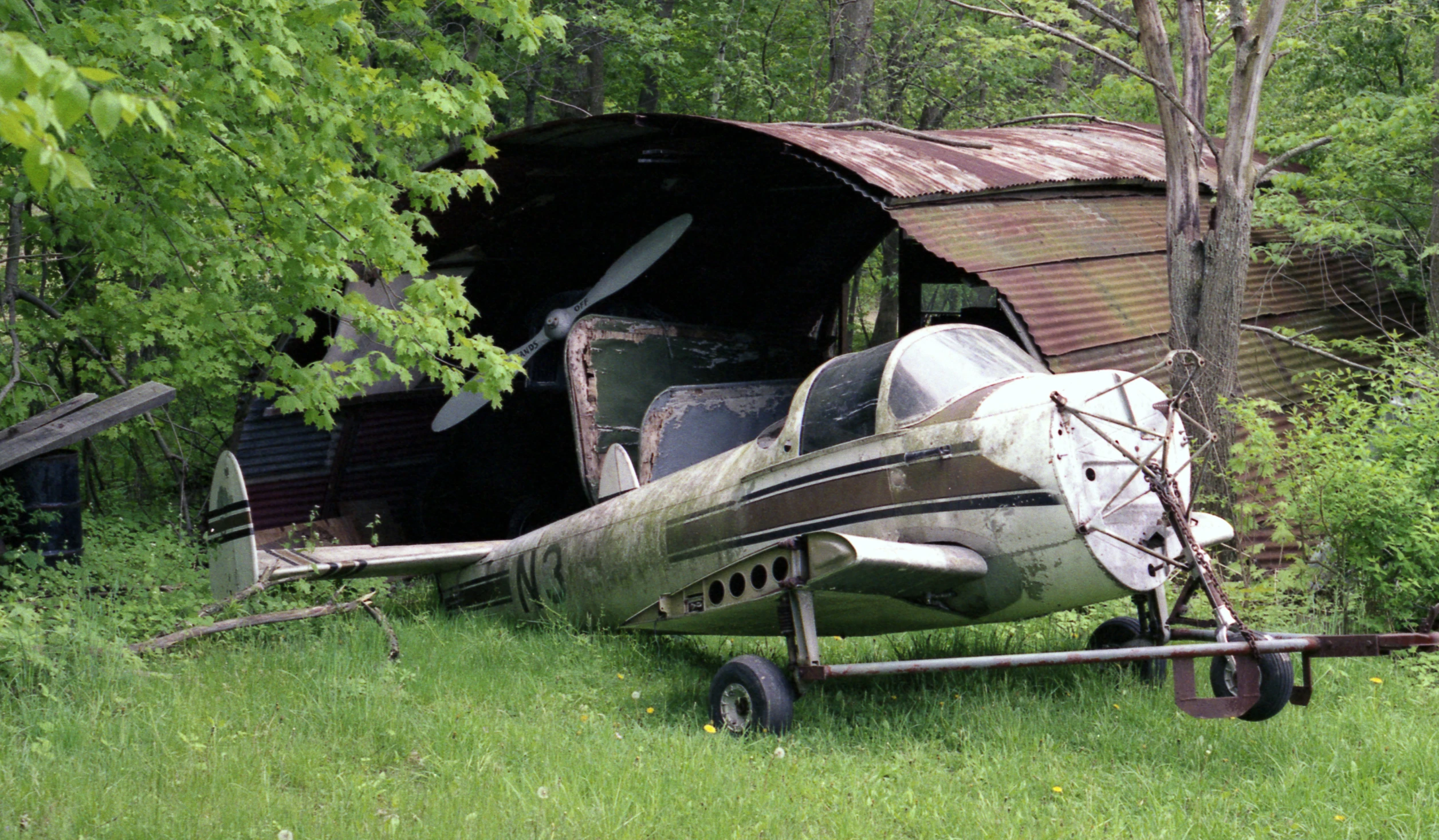 a small airplane parked next to a wooden structure