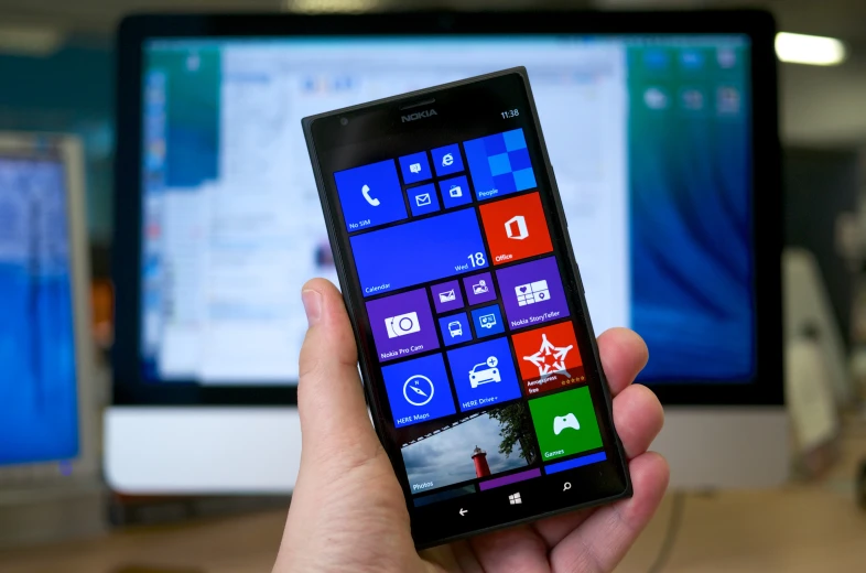 a person holding an iphone showing the windows app