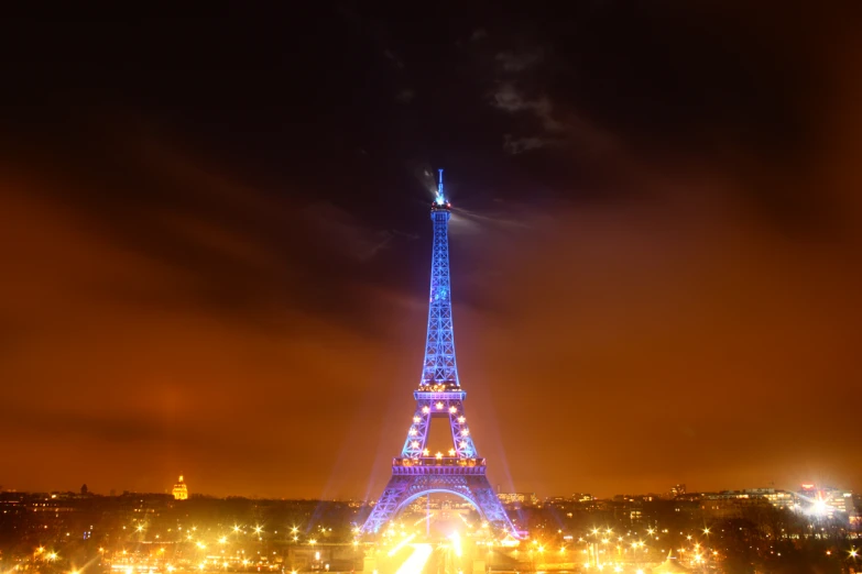 the eiffel tower lit up at night with the lights on