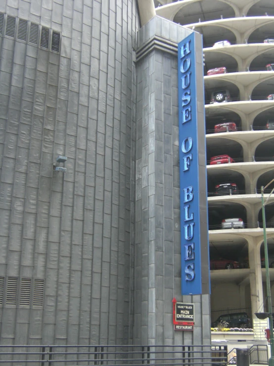 a parking lot near a very tall building with a large blue sign