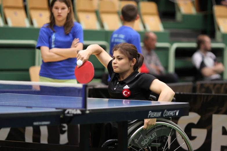 the women is playing table tennis outside