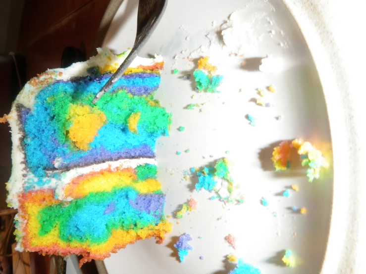 there is a large rainbow cake on a plate