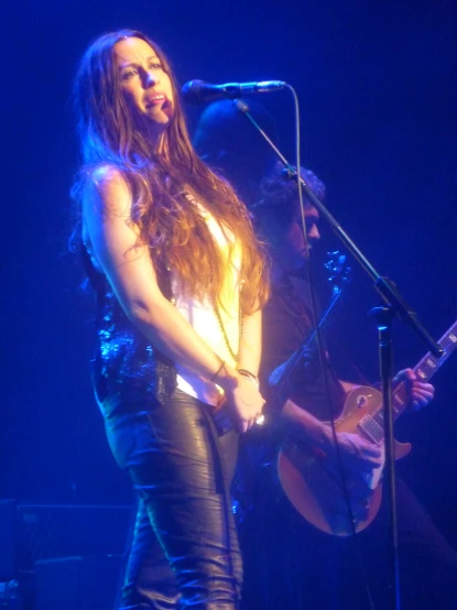 a woman singing in front of a microphone