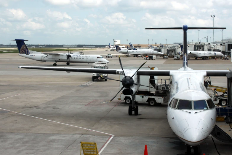 two propeller airplanes on the run way at the airport