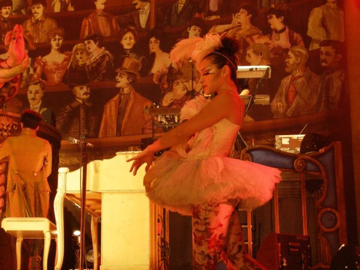 a woman in a pink outfit and heels on stage