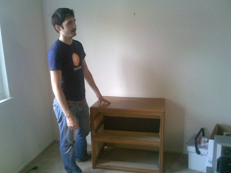 the young man is standing near a small table