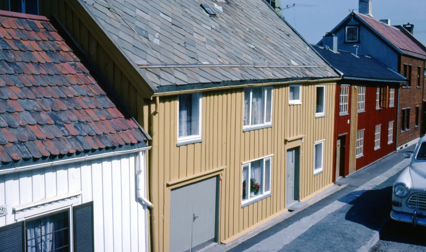 a row of houses on a hill with the garages painted yellow