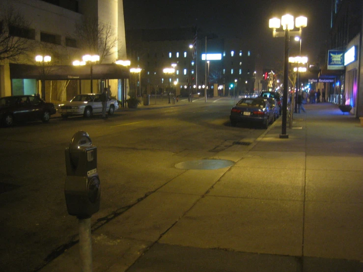 an empty city street at night with lots of lights