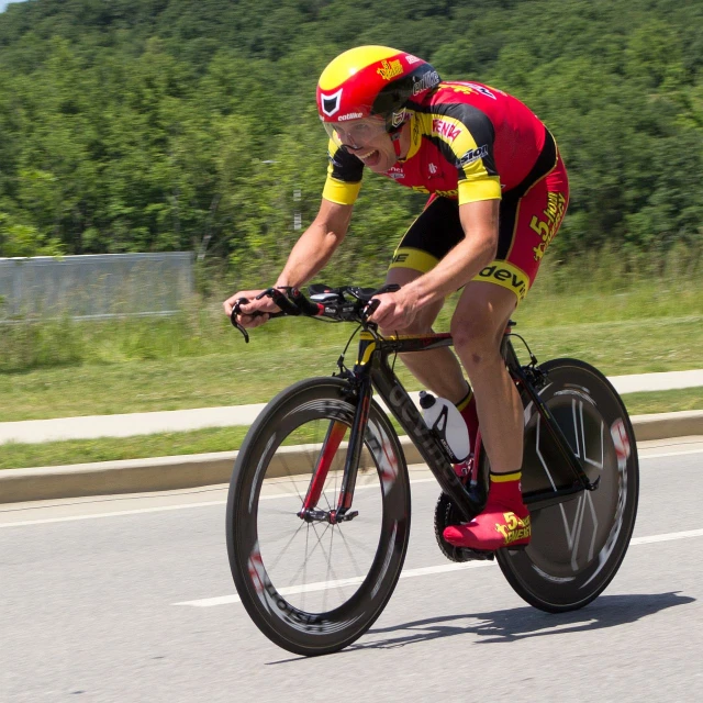 the man in red is riding his bicycle on a street