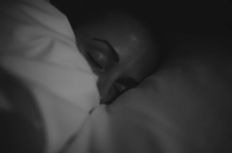 a woman sleeping in bed under the covers