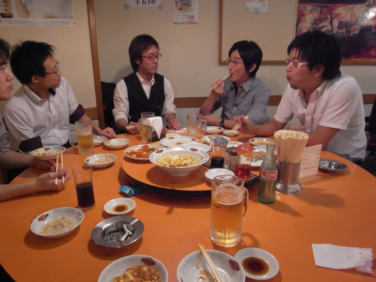 five people sitting around a table full of plates of food