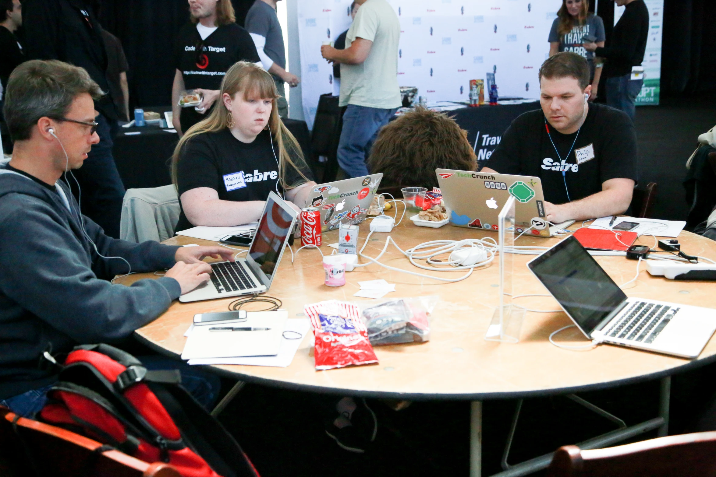 a group of people in black shirts using laptops on a table