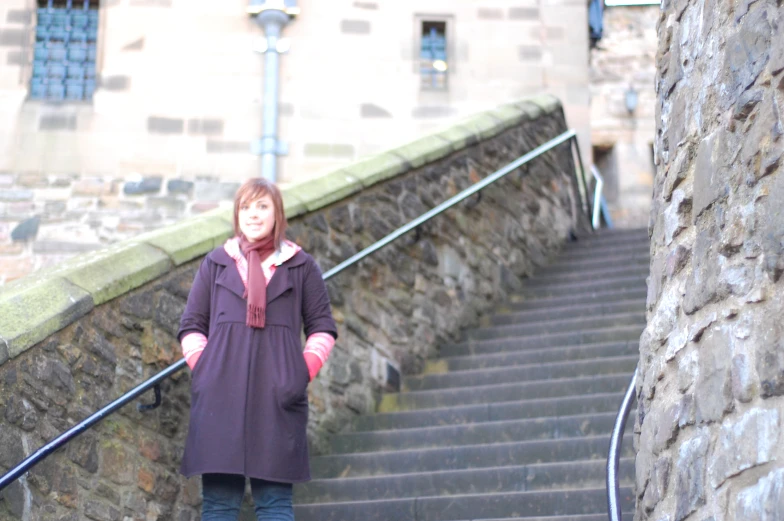 a woman walking up steps in front of an old building