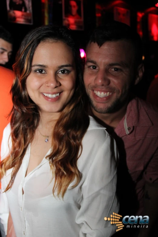 the smiling woman and man are standing together