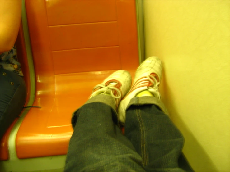 legs and shoes are visible while seated on a bus