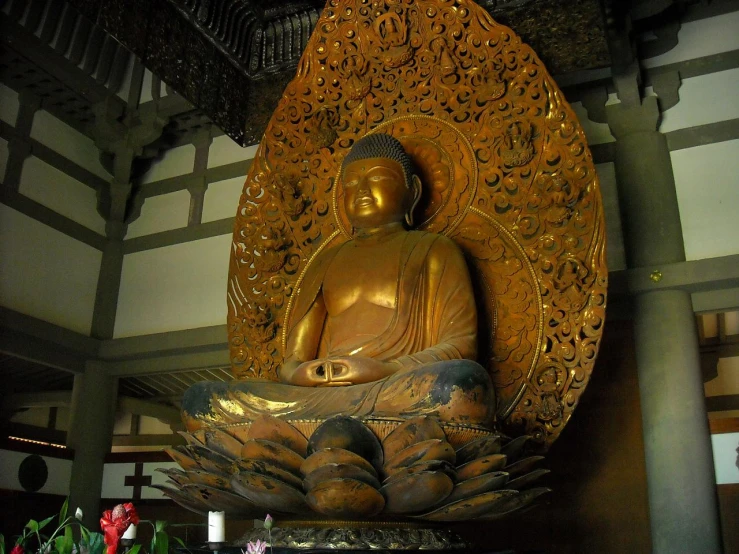 a buddha statue sitting on a pedestal in a room