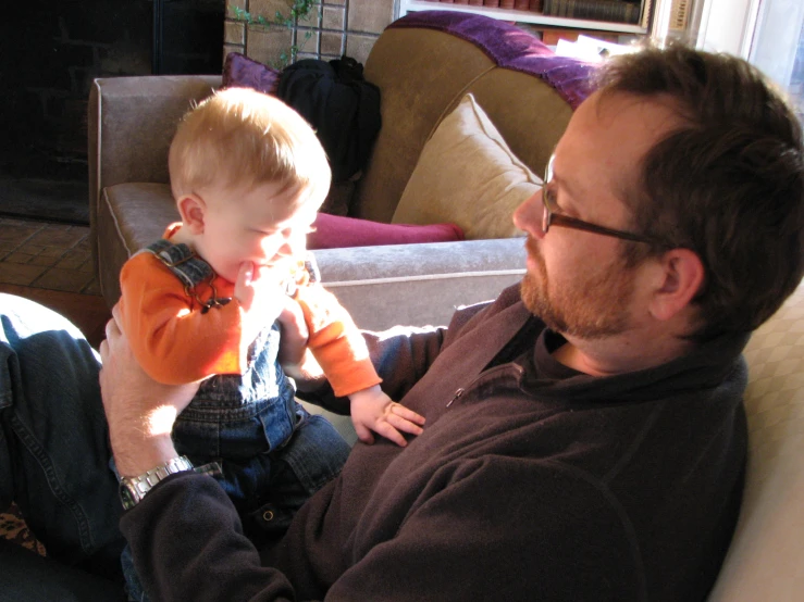 a man holding a small boy in his lap