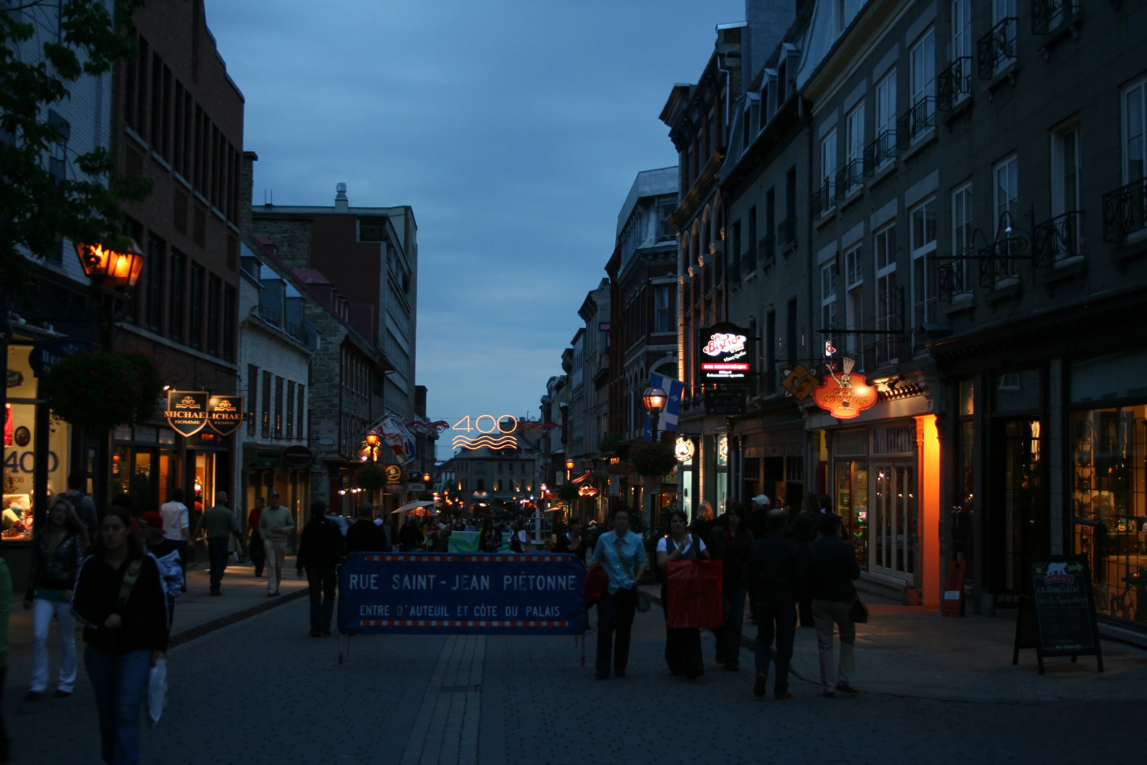 people on the side walk under their signs