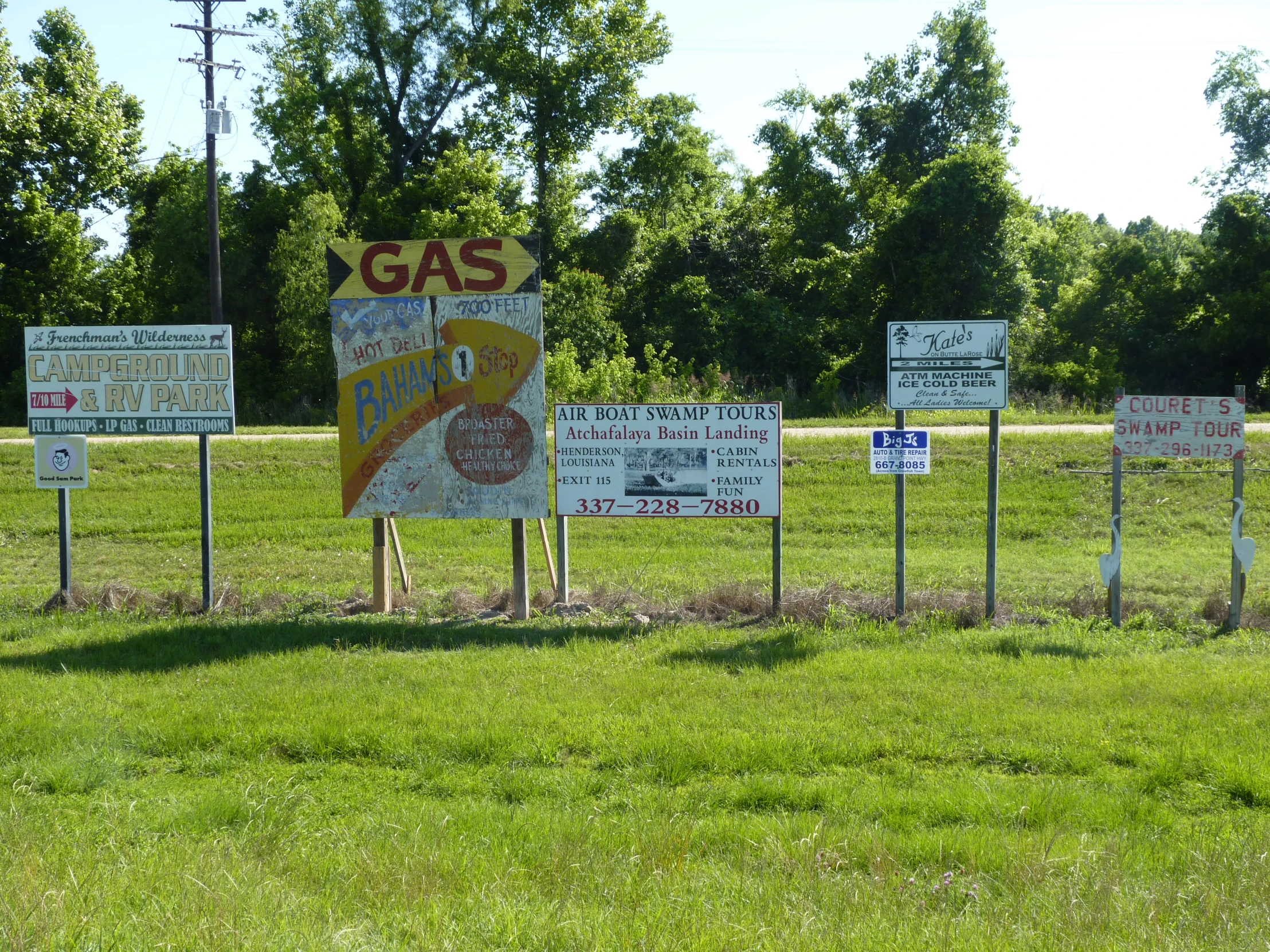 a group of signs sitting in a grass covered field