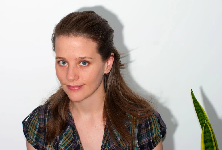 a woman in plaid shirt with potted plant