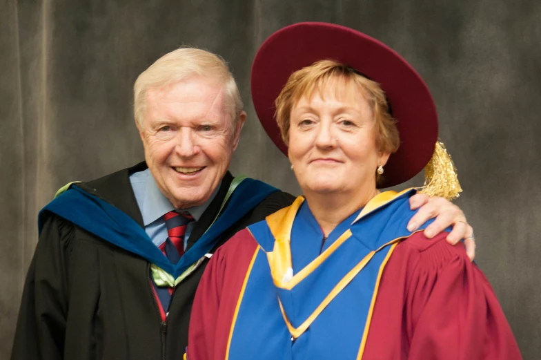 a woman and man posing together in robes