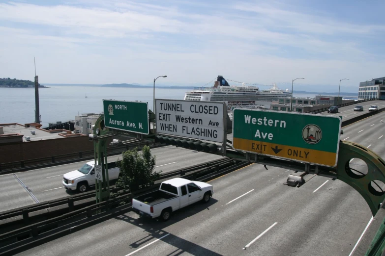 a large billboard for western and a couple of cars driving down a highway