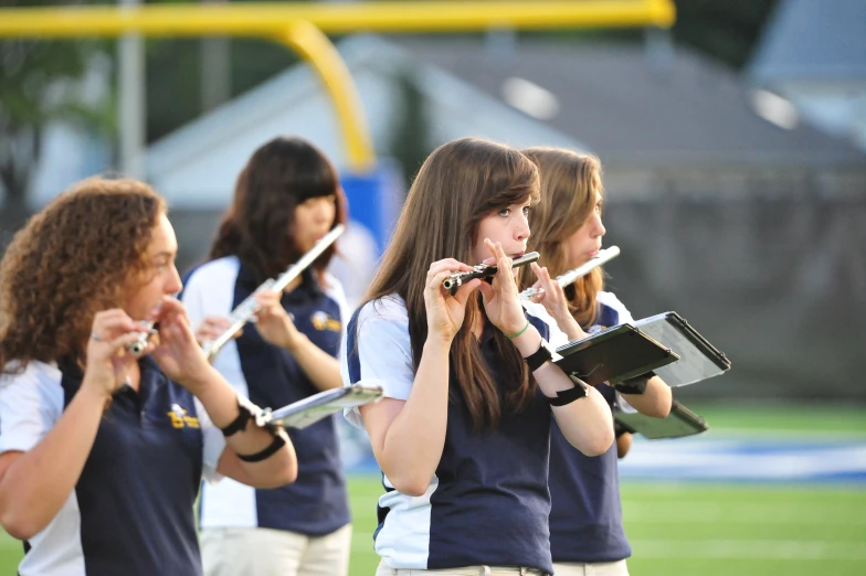 several girls are playing flutes on the field