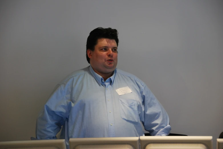 a man with a badge on his shirt making a goofy face