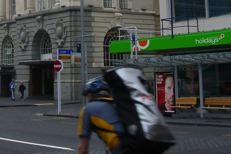 two people walking on the side walk of a city street