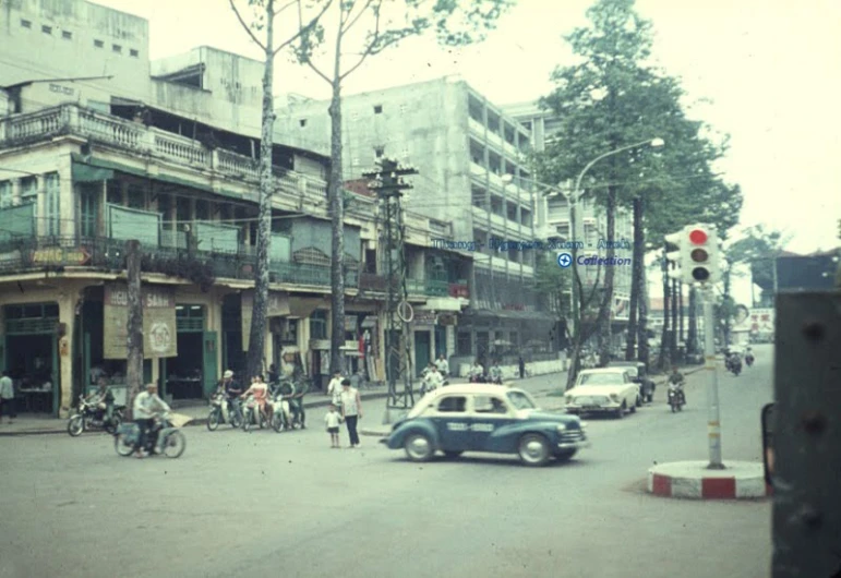 there are many people on the street, and a car stopped at an intersection