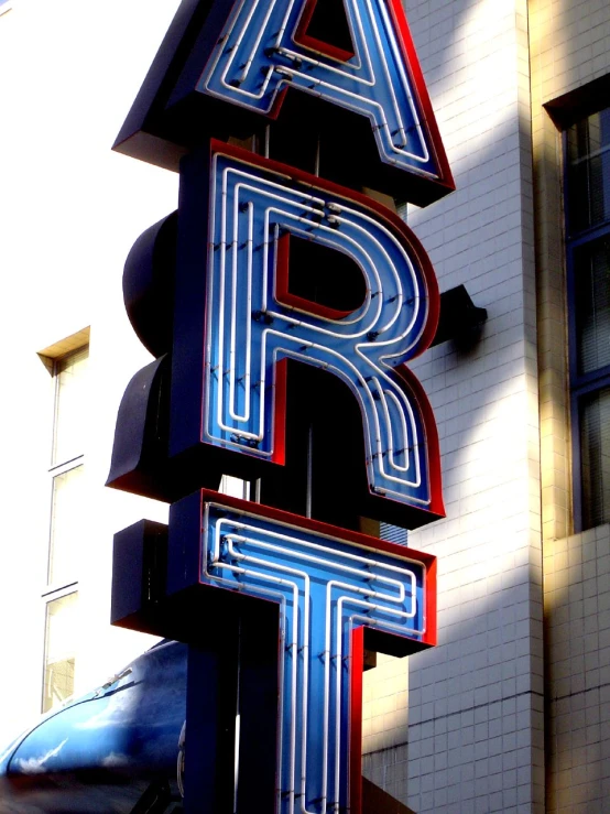 the large neon sign for a business on the side of the building